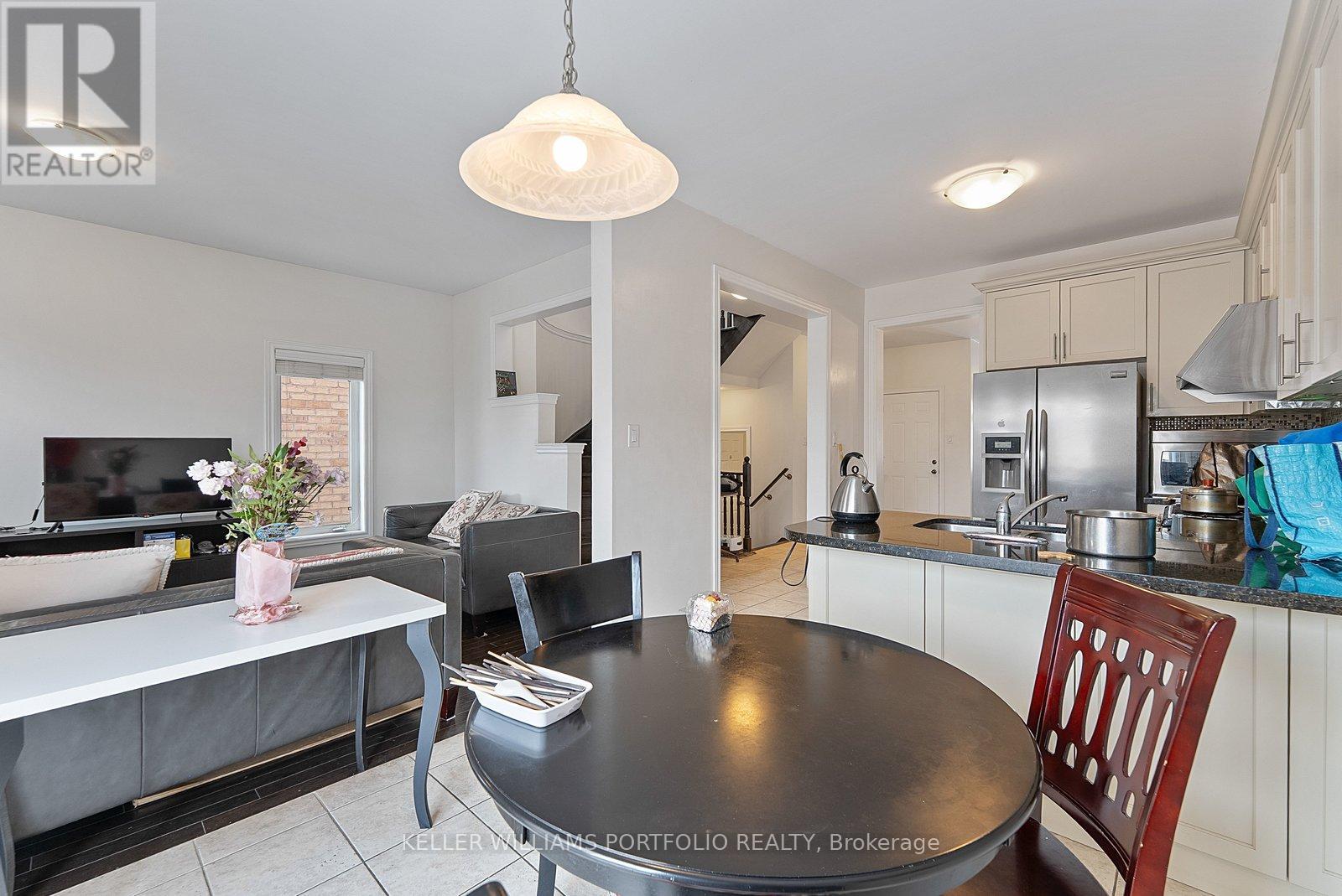 A kitchen with a table and chairs in the foreground and a living room in the background.