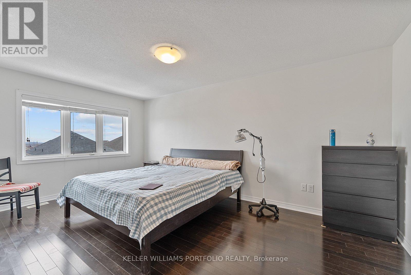 A bedroom with a bed, nightstand, and chair.