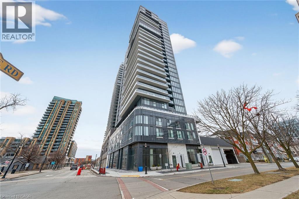 A tall building with a glass facade stands in front of a smaller building with a white facade.
