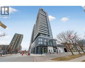 A tall building with a glass facade stands in front of a smaller building with a white facade.