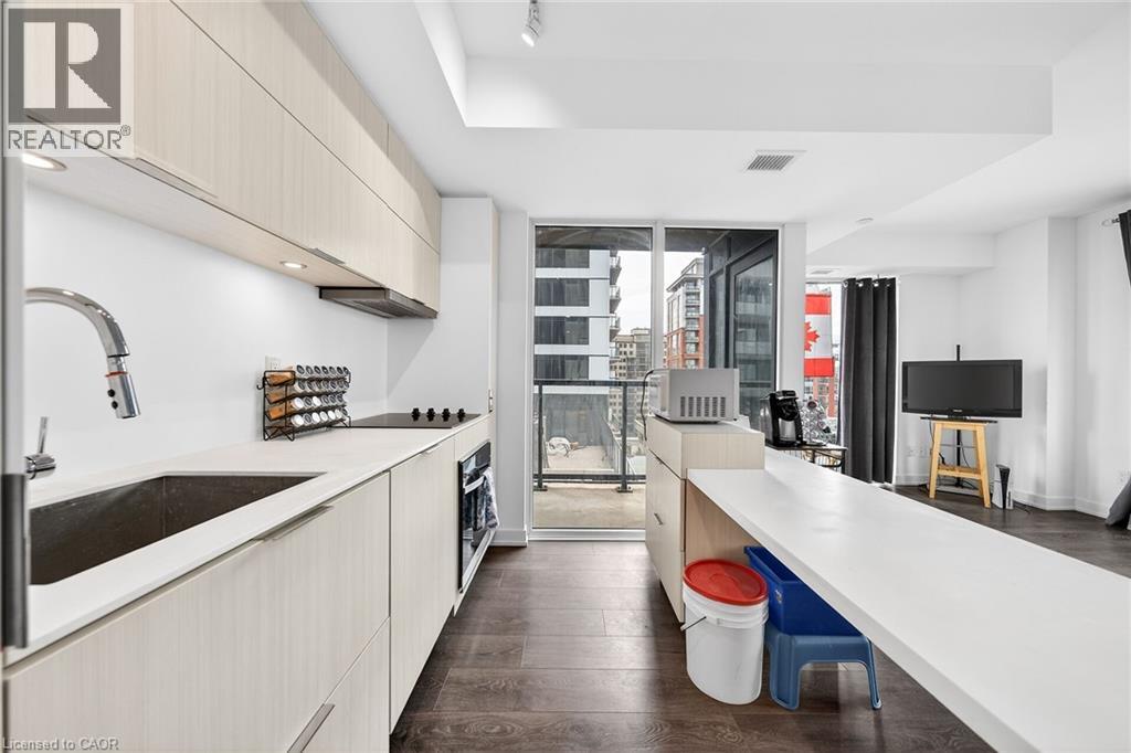 A modern kitchen with white cabinets and a wooden floor.