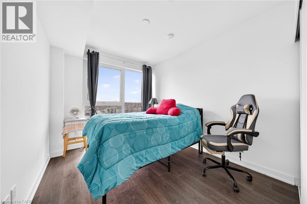 A bedroom with a bed, chair, and window.