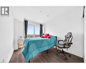 A bedroom with a bed, chair, and window.