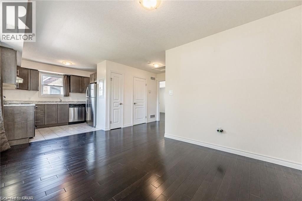 A spacious room with wooden flooring and white walls.