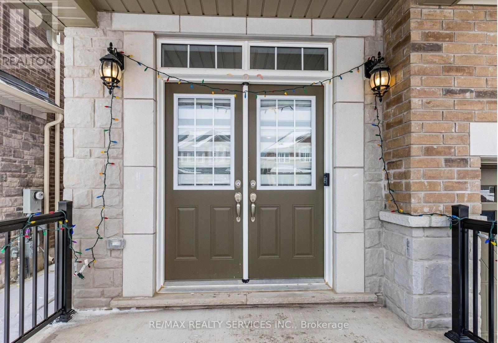 A house entrance with a green door and a sign that says RE/MAX Realty Services INC Brokerage.