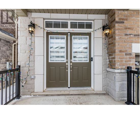 A house entrance with a green door and a sign that says RE/MAX Realty Services INC Brokerage.