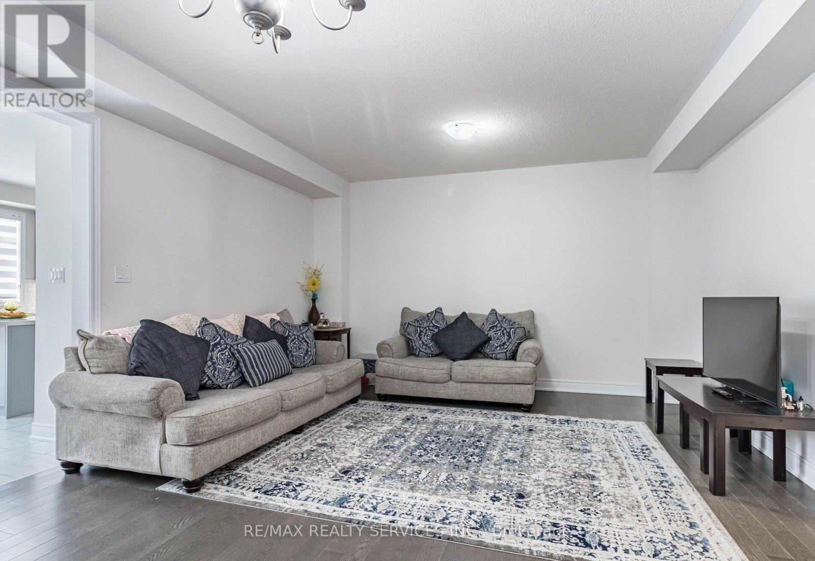 A living room with a grey couch and a blue rug.