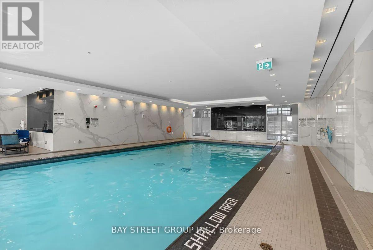 A large indoor swimming pool with a sign that says "Bay Street Group Inc. Brokerage".