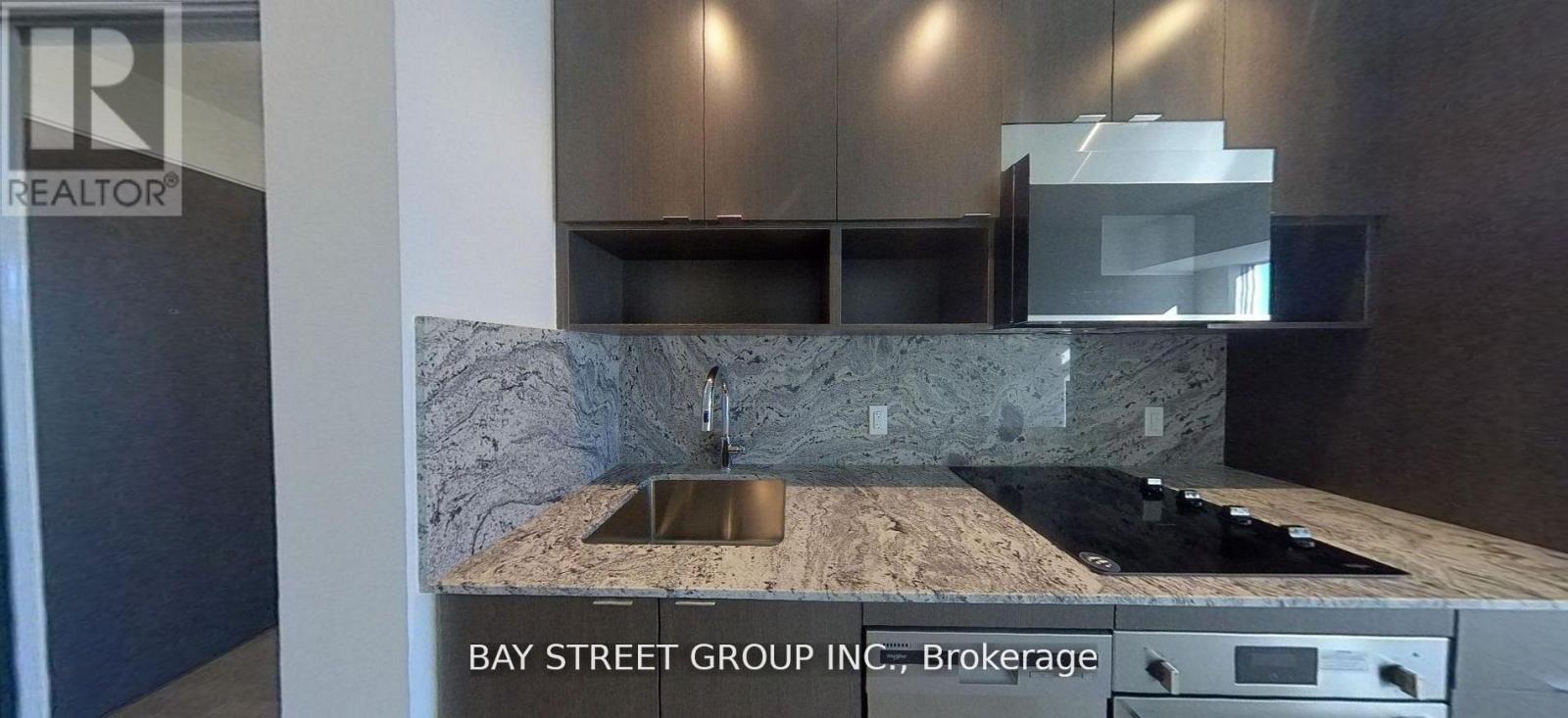 A kitchen with a marble countertop and stainless steel appliances.