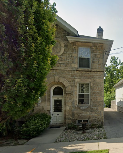 A small stone house with a white door and window.