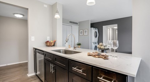 A modern kitchen with a white countertop and black cabinets.