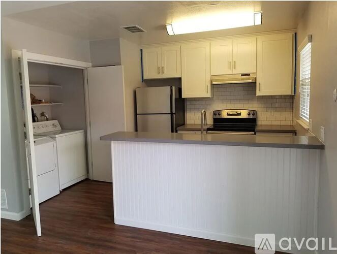 A kitchen with white cabinets and a stainless steel refrigerator.