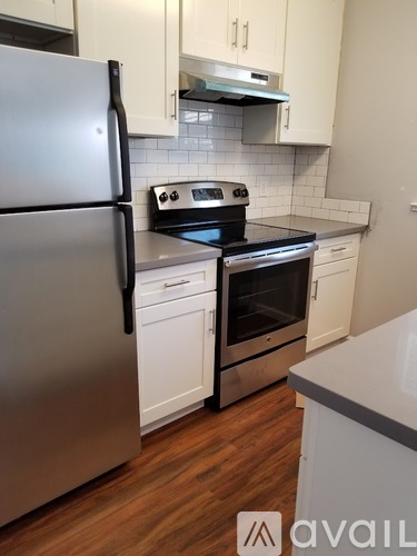 A kitchen with a stainless steel refrigerator and white cabinets.