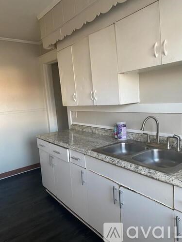A kitchen with white cabinets and a granite countertop.