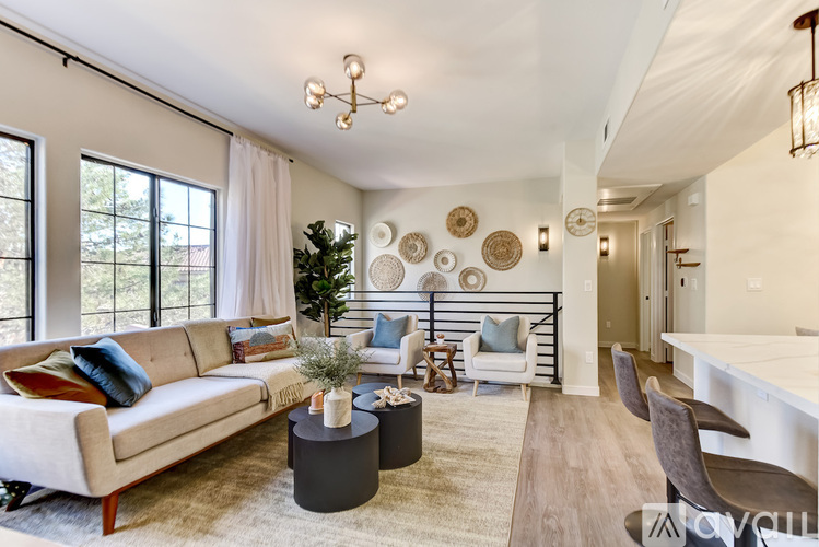 A living room with a couch, a coffee table, and a chandelier.
