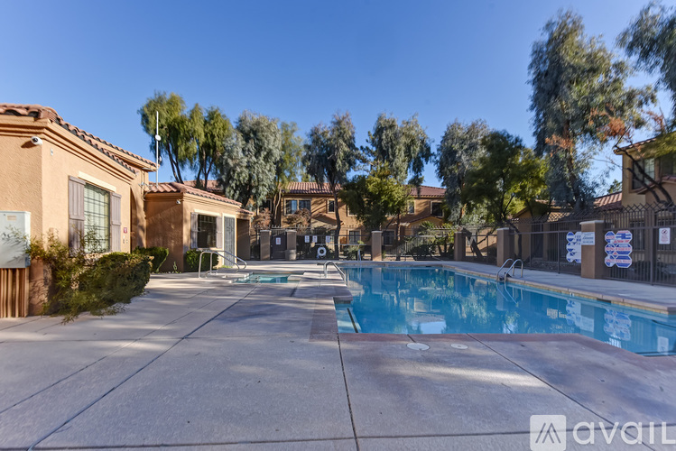 A pool surrounded by houses and trees.