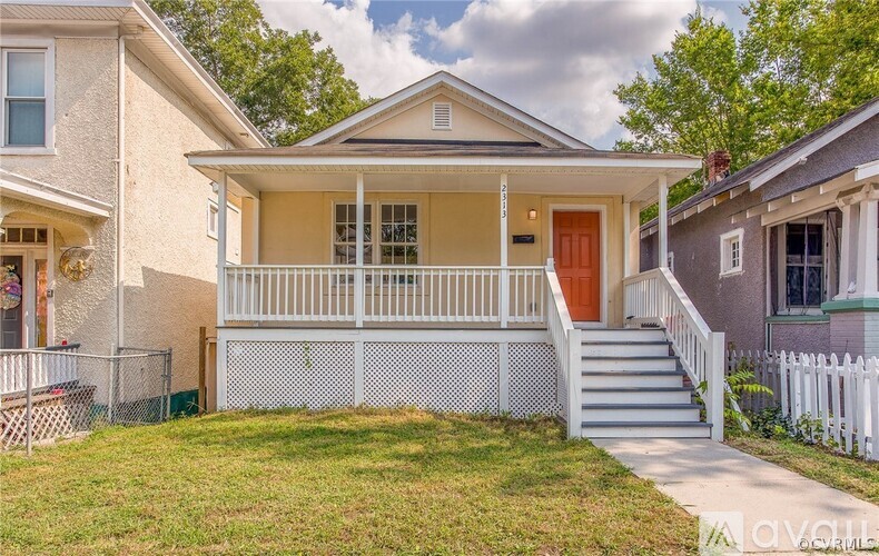 A house with a white porch and a red door.