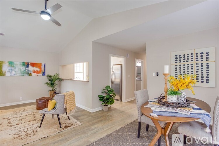 A dining room with a table set for two and a ceiling fan.
