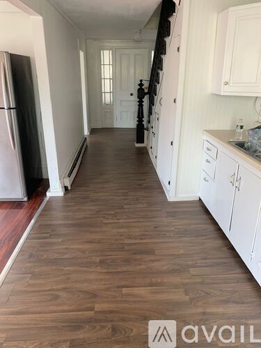 A kitchen with white cabinets and a black refrigerator.