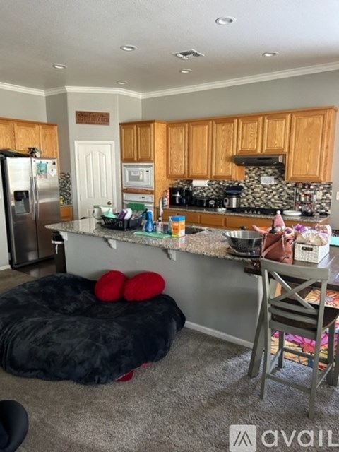 A kitchen with a refrigerator, microwave, and oven.