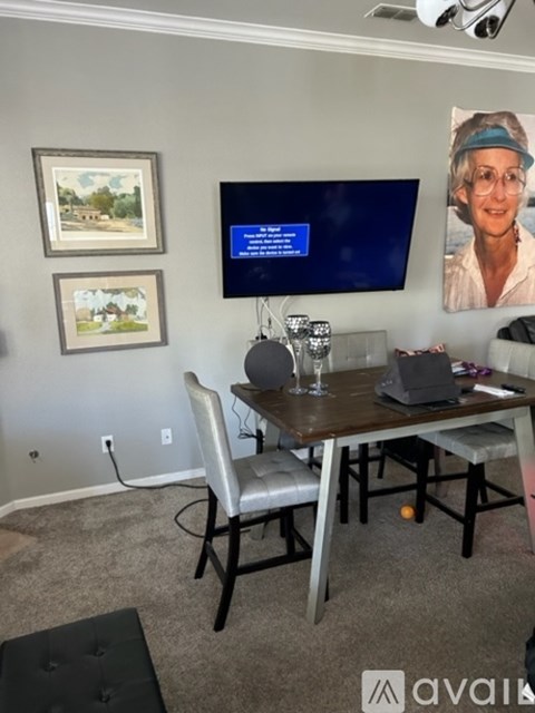A room with a table, chairs, and a television displaying a blue screen.
