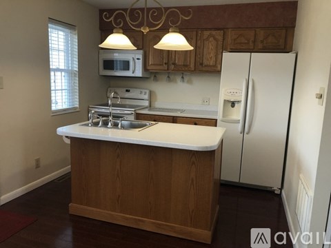 A kitchen with a white counter top and a white refrigerator.