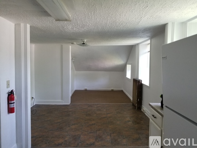 A room with brown tile flooring and white walls.