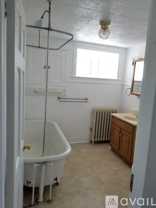 A bathroom with a claw foot tub and a window.
