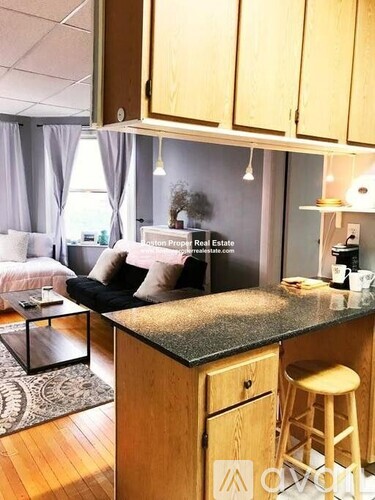 A kitchen with a black granite countertop and wooden cabinets.