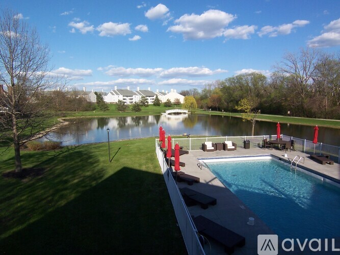 A pool with a view of a lake and trees.