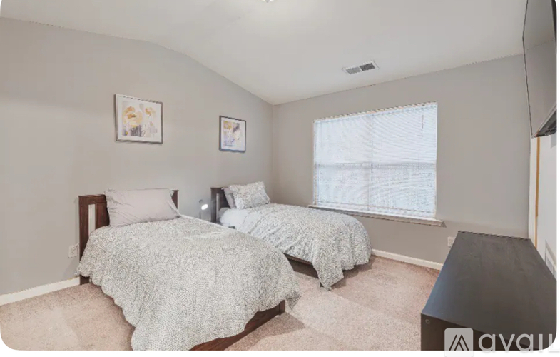 A bedroom with two beds and a window.