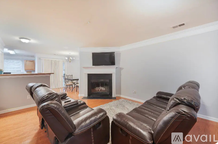 Two brown leather couches in a living room with a fireplace.
