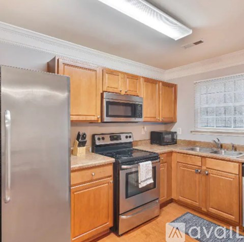 A kitchen with wooden cabinets and stainless steel appliances.