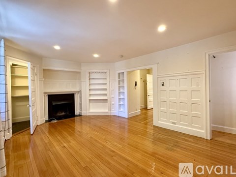 A white shelving unit in a room with a fireplace.