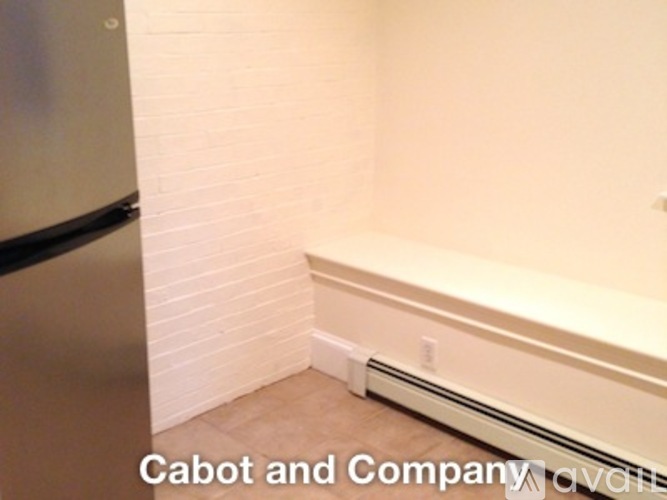 A white wall with a heater under it.