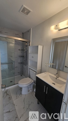 A bathroom with a toilet, sink, and shower.