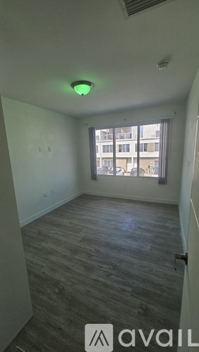 A room with a window and a view of a building outside.