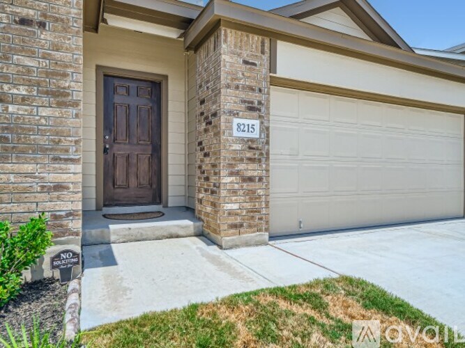 A house with a brown door and a garage door.