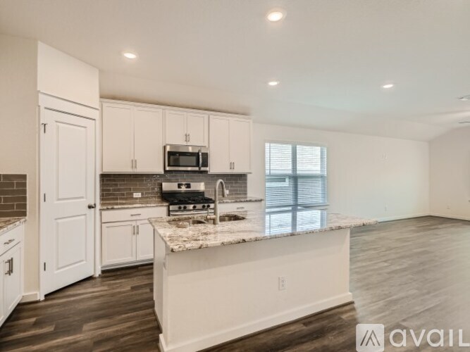 A kitchen with white cabinets and a marble countertop.