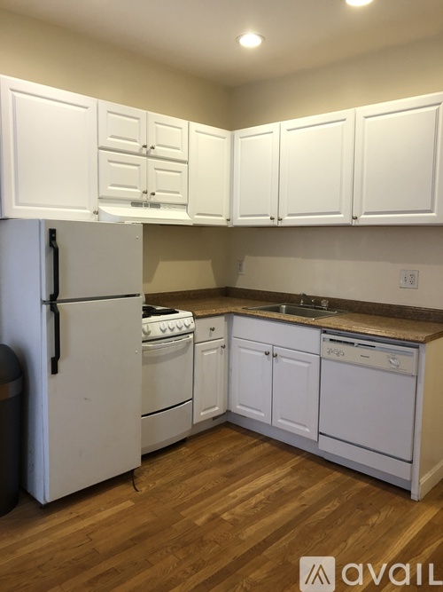 A kitchen with white appliances and cabinets.