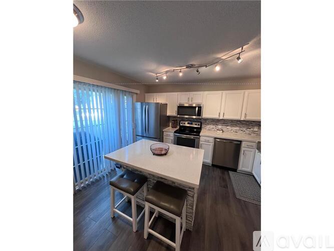 A kitchen with a table and chairs in front of a window.