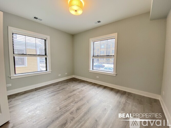 A room with a window and a wooden floor.