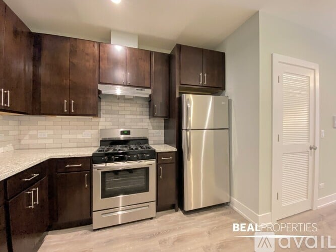 A kitchen with dark brown cabinets and a stainless steel refrigerator.