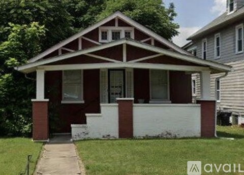 A small house with a red and white front porch.