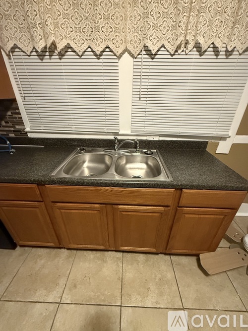 A kitchen with a sink and wooden cabinets.