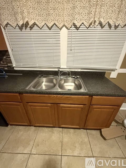 A kitchen with a sink and wooden cabinets.
