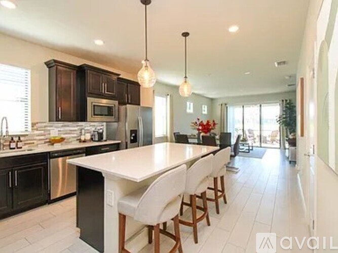 A modern kitchen with dark wood cabinets and a white island.