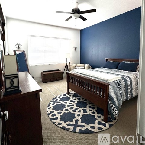 A bedroom with a bed, dresser, and window.