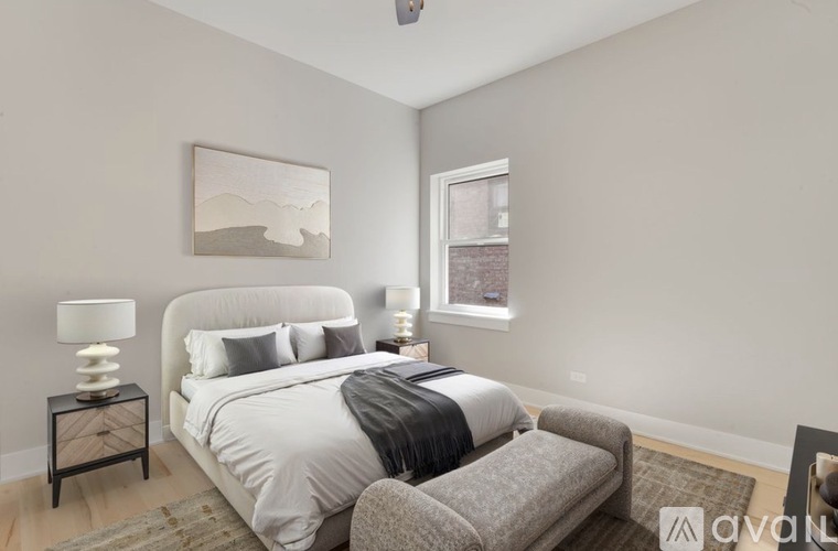 A bedroom with a large bed and a grey couch.
