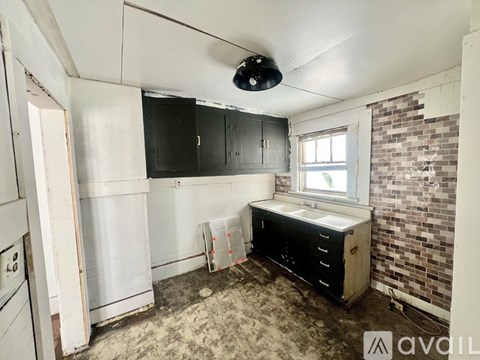 A kitchen under renovation with a brick wall and a window.